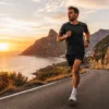 Runner training on a scenic coastal road at golden hour — endurance exercise and fitness concept
