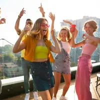 Young people rooftop party dancing - energetic active lifestyle supplement